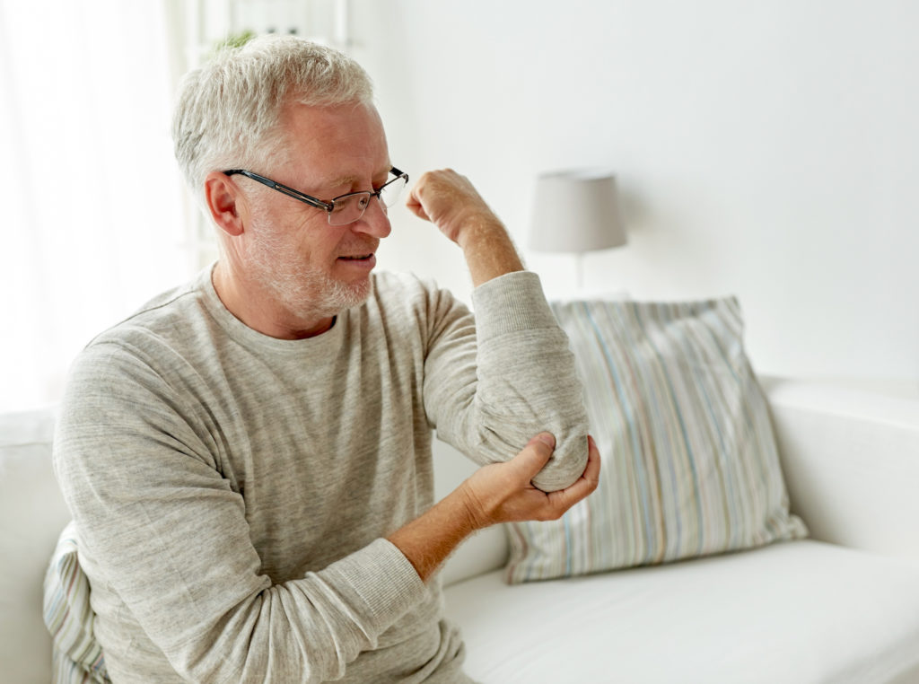 old man holding his elbow pain