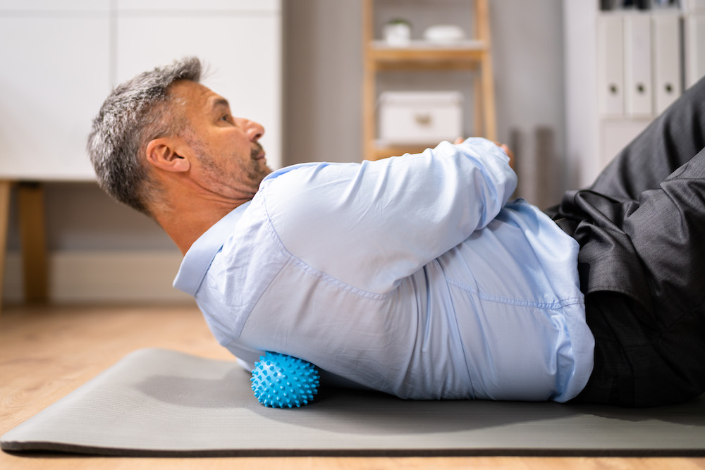 man having a Back Trigger Point Massage Using Spiky Ball Myofascial Release
